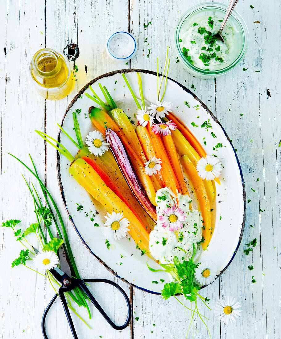 Steamed colourful carrots with curd dip and daisies