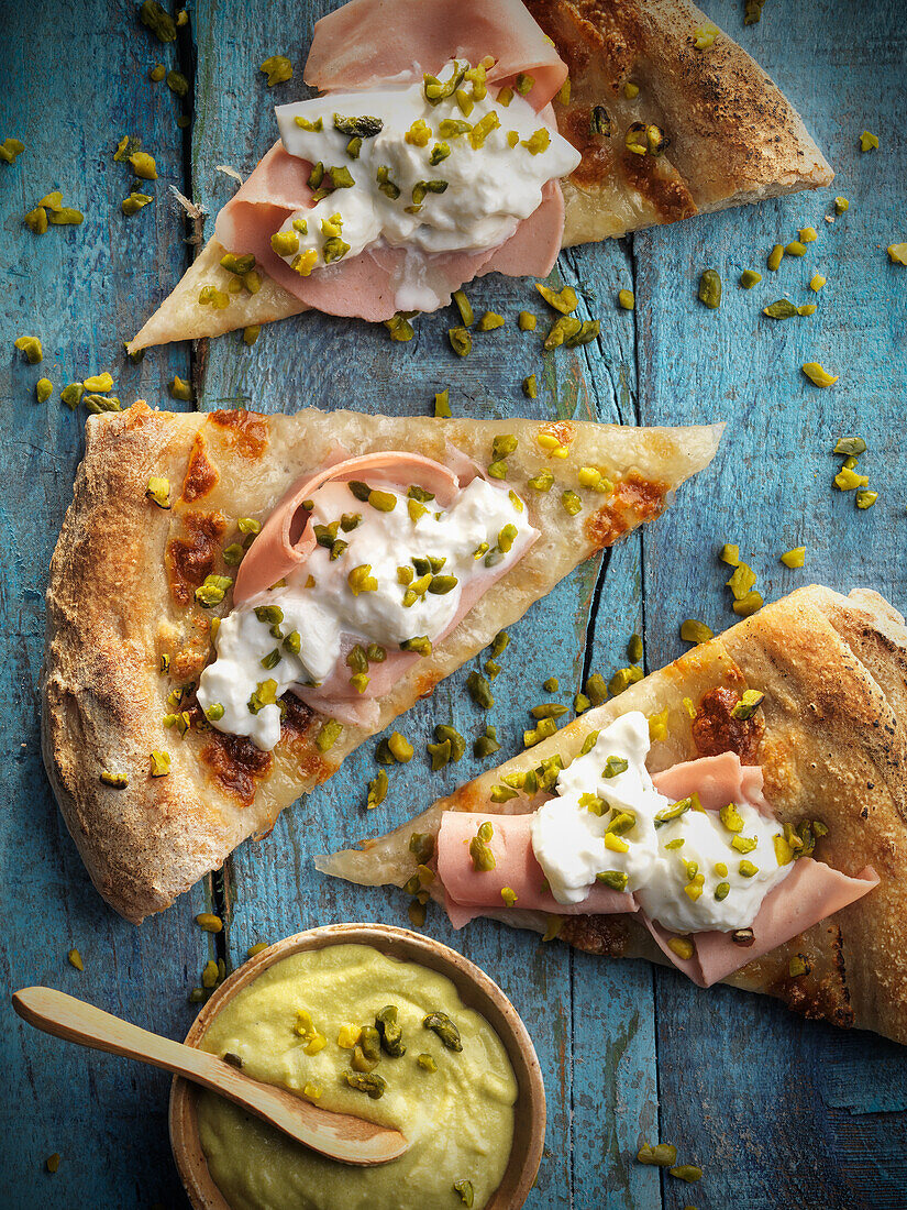 Pizza with cooked ham, burrata and pistachios