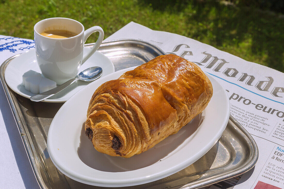 French breakfast - Pain au chocolat with café noir and newspaper