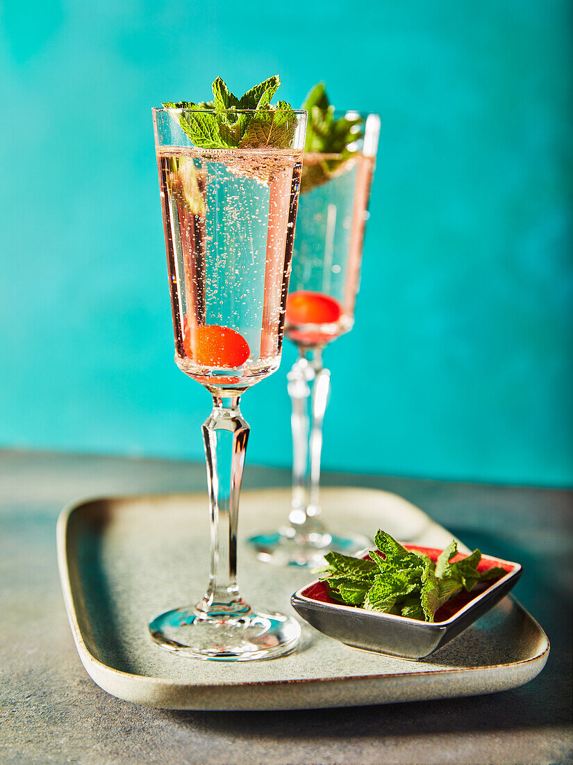 Two glasses of Gin Fizz with pomegranate seeds and mint