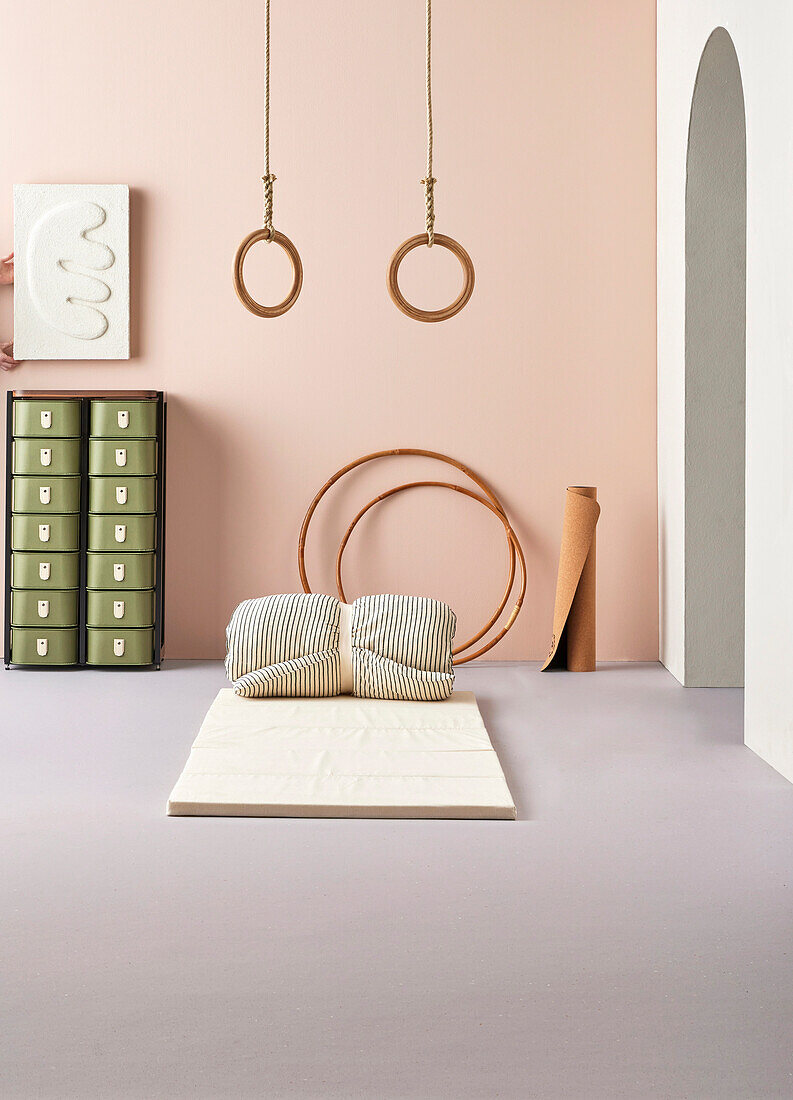 Equipment for the home gym: gym mat, gymnastic rings, hula hoops and shelf with olive green boxes