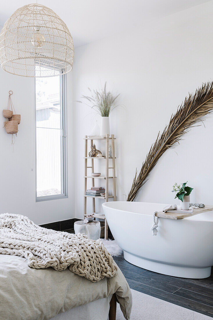 Palmwedel hinter freistehender Badewanne im Schlafzimmer