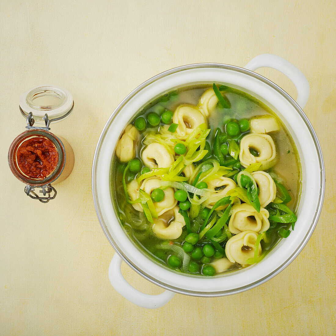 Vegan tortellini soup with peas and leeks
