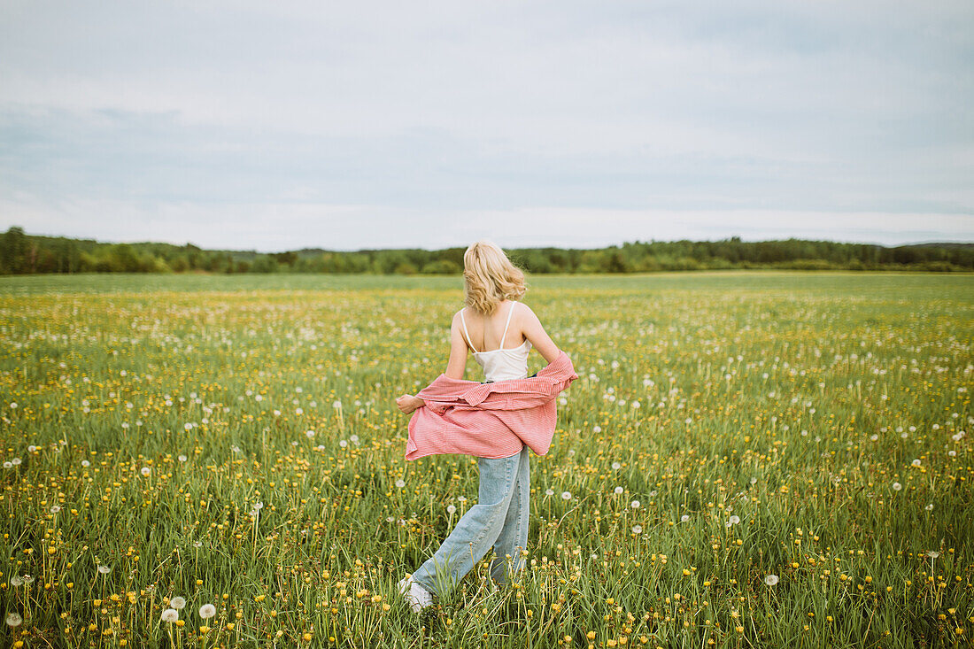 Junge blonde Frau auf einer sommerlichen Blumenwiese