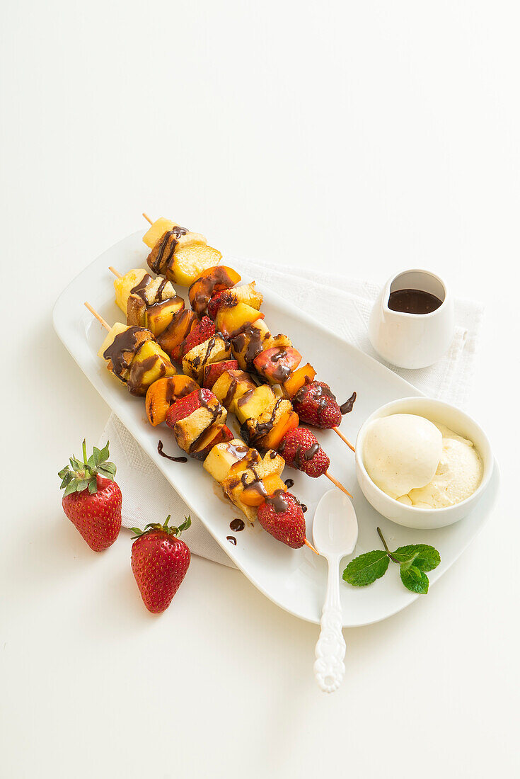 Fruit skewers with brioche bread and chocolate sauce, served with vanilla ice cream