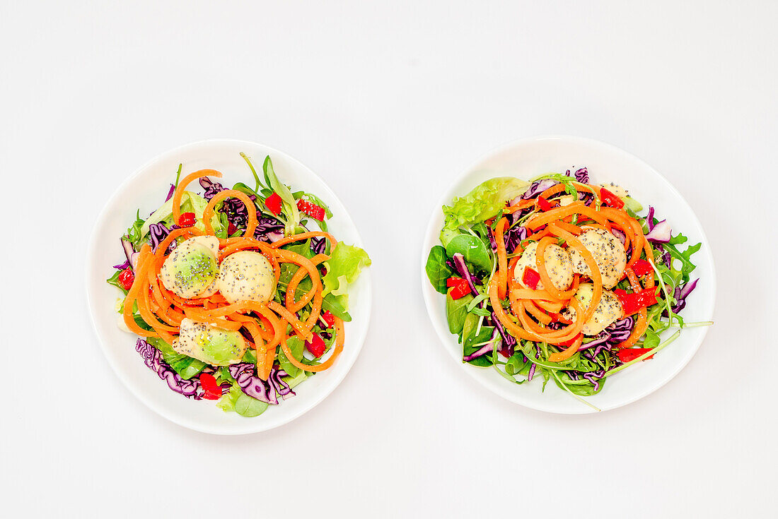 Carrot noodles and poppy seed avocado balls on salad