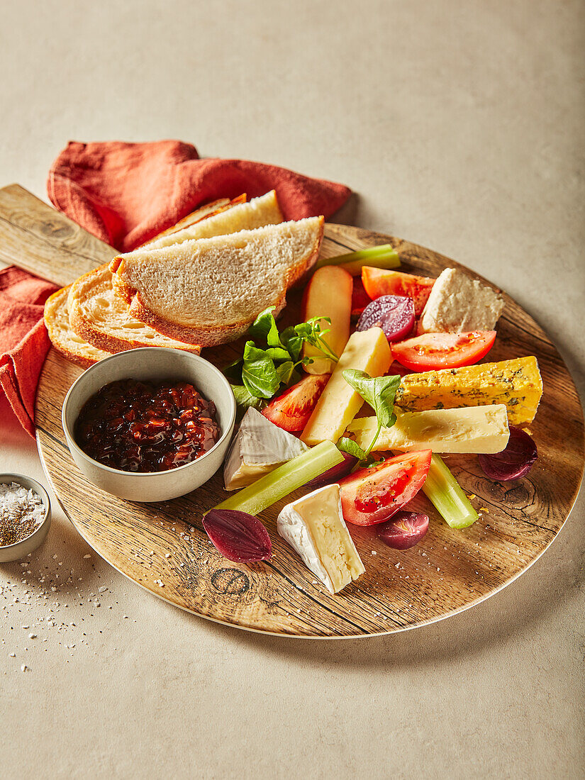 Englischer Käse mit Chutney und Brot auf Holzplatte