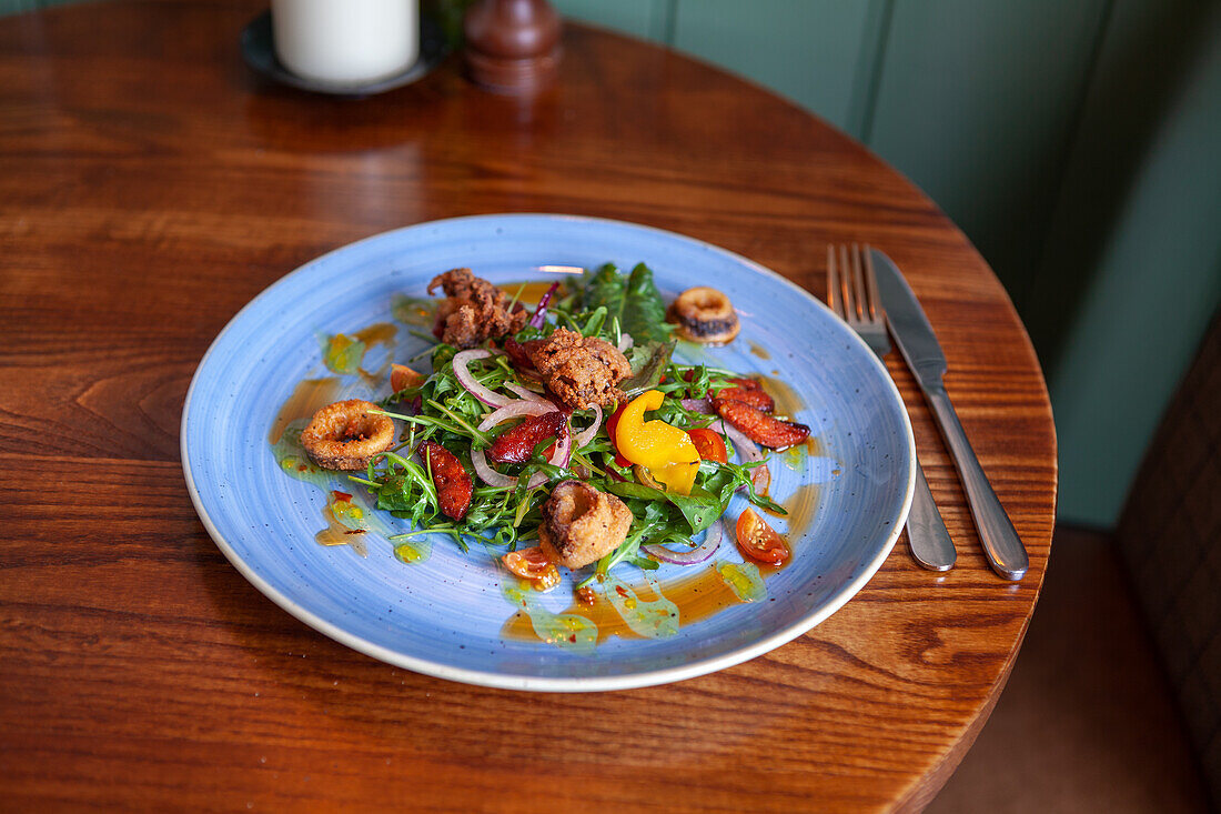 Salat mit ofengerösteten Tomaten, Paprika, roter Zwiebel und Tintenfisch