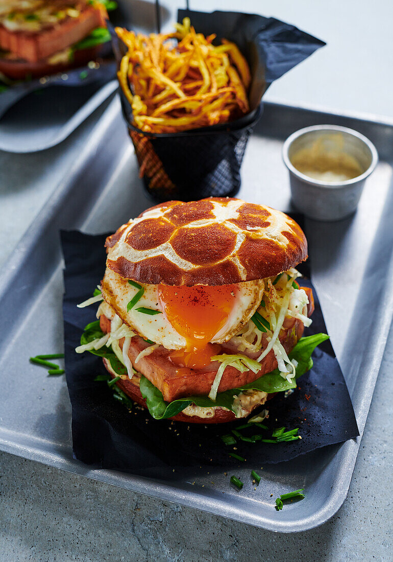 Leberkäse (meatloaf) burger with a fried egg and a basket of fries