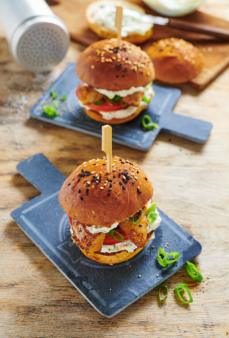 Mini chicken burgers with crème fraîche on a slate board