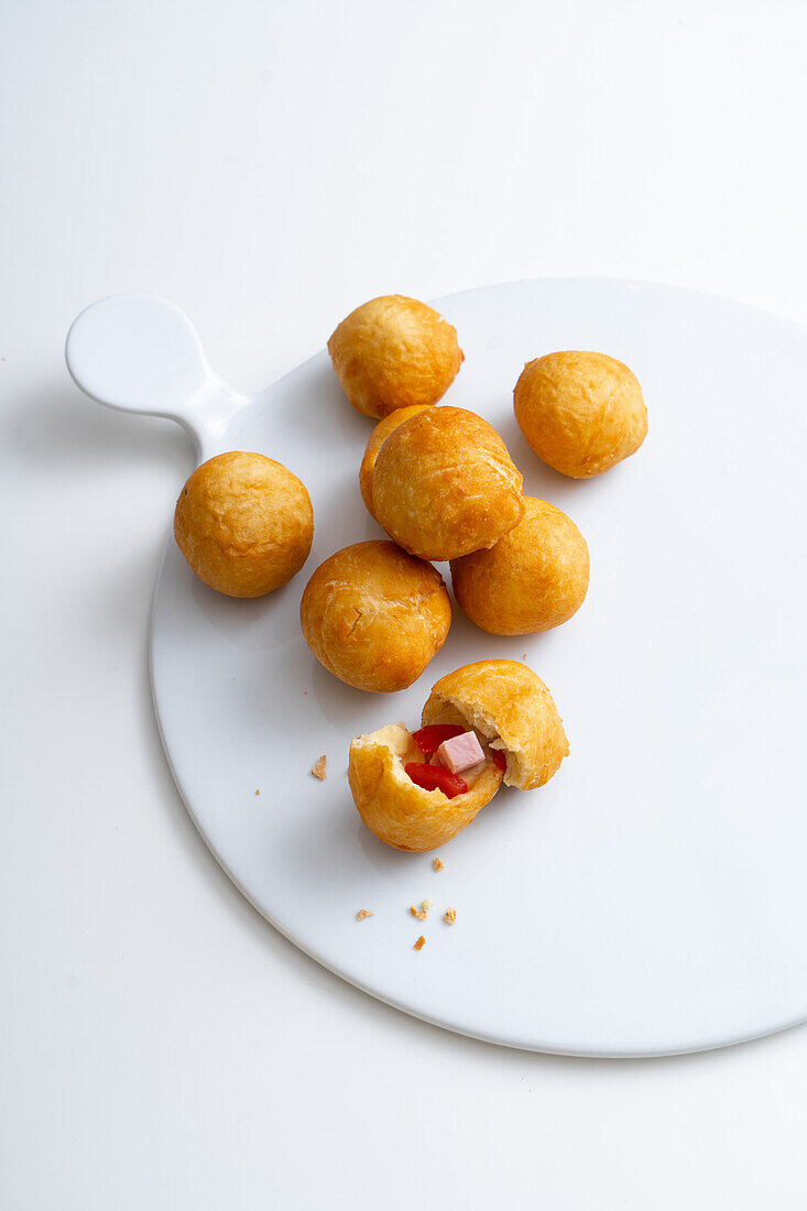 Deep-fried pizza balls with mozzarella, ham and tomatoes