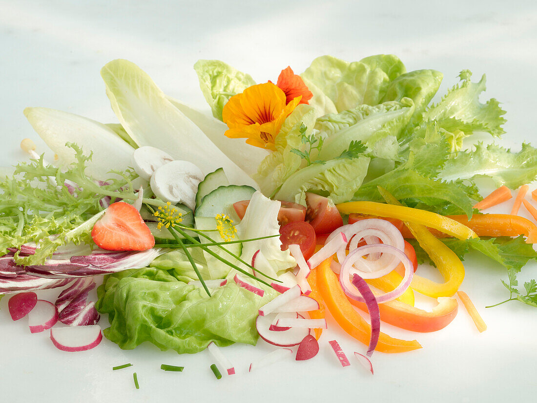 Hellgrüner Salat und verschiedene andere Salatzutaten