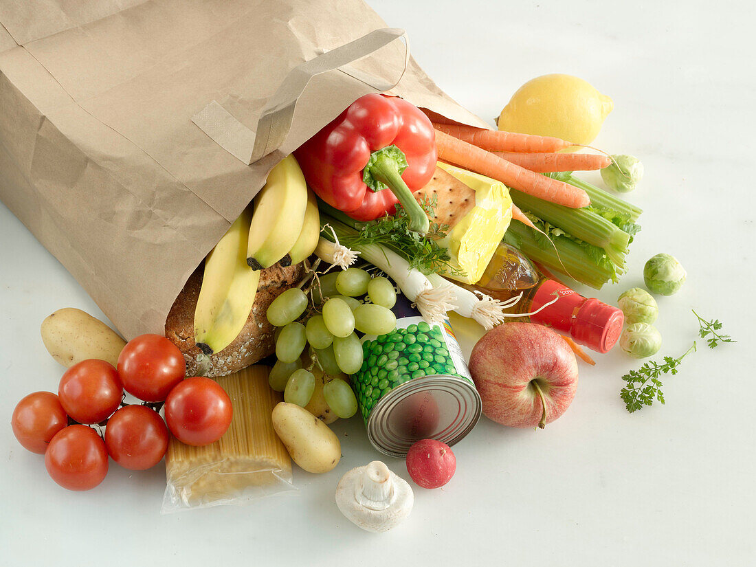Paper bag with groceries - vegetables, fruit, pasta, cheese, and oil