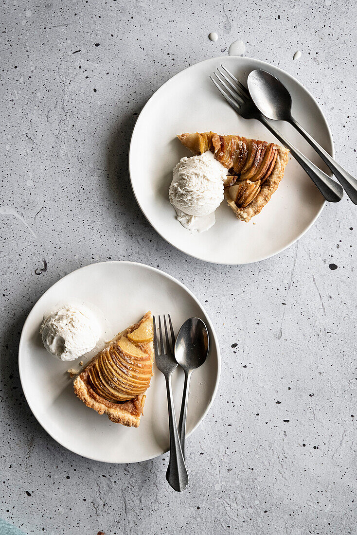 Bratapfelkuchen mit Eis auf Kuchentellern