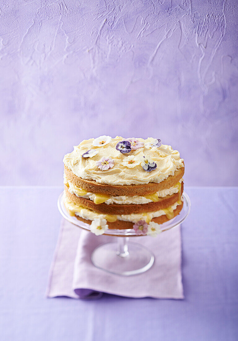 Lemon-Curd-Schichttorte dekoriert mit Blüten