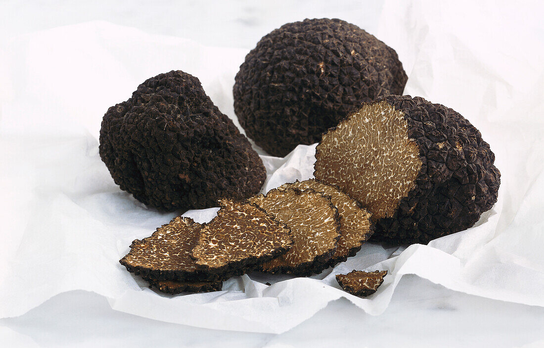 Truffles and truffle slices on a white cloth