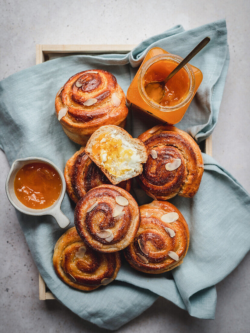 Cinnamon buns with almond flakes served with jam and honey