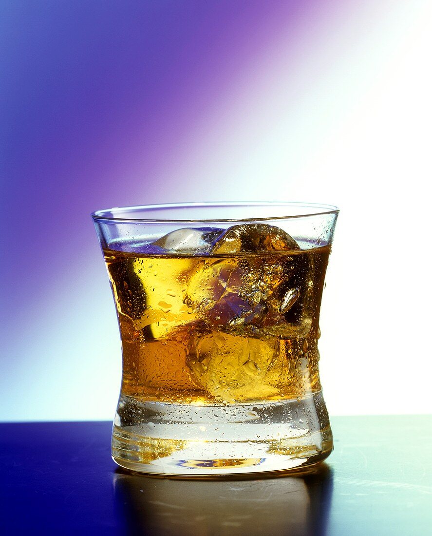 A glass of Rusty Nail with ice cubes