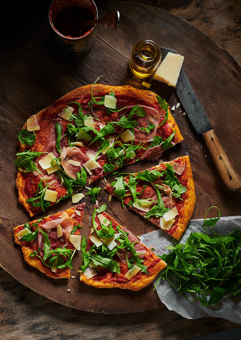 Pizza with Parma ham and rocket on pizza board