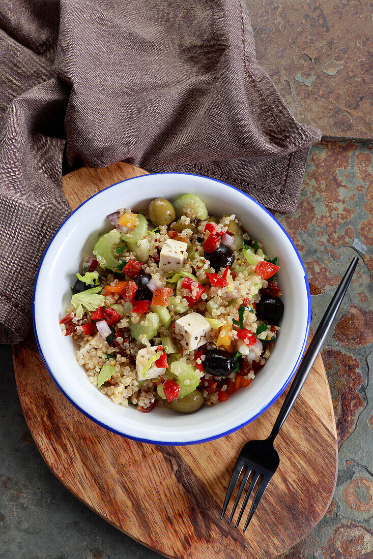 Salad with quinoa, olives, celery, paprika, and feta cheese