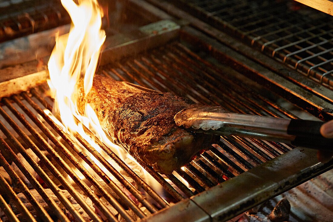 Beef steak being grilled on a flame