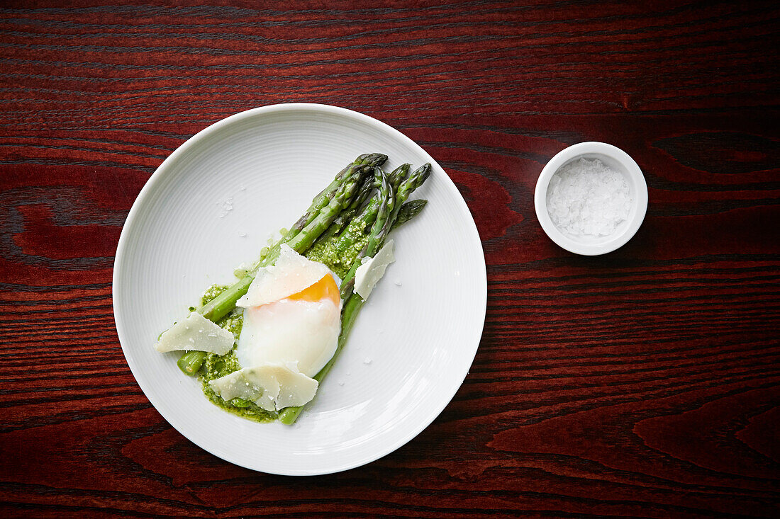 Asparagus served with a poached egg, pesto and shavings of parmesan