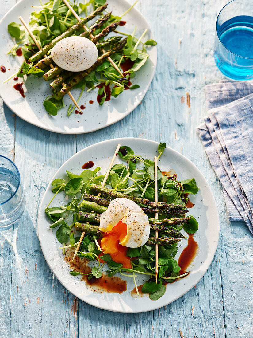 Green asparagus with soft-boiled egg and Asian dressing on watercress