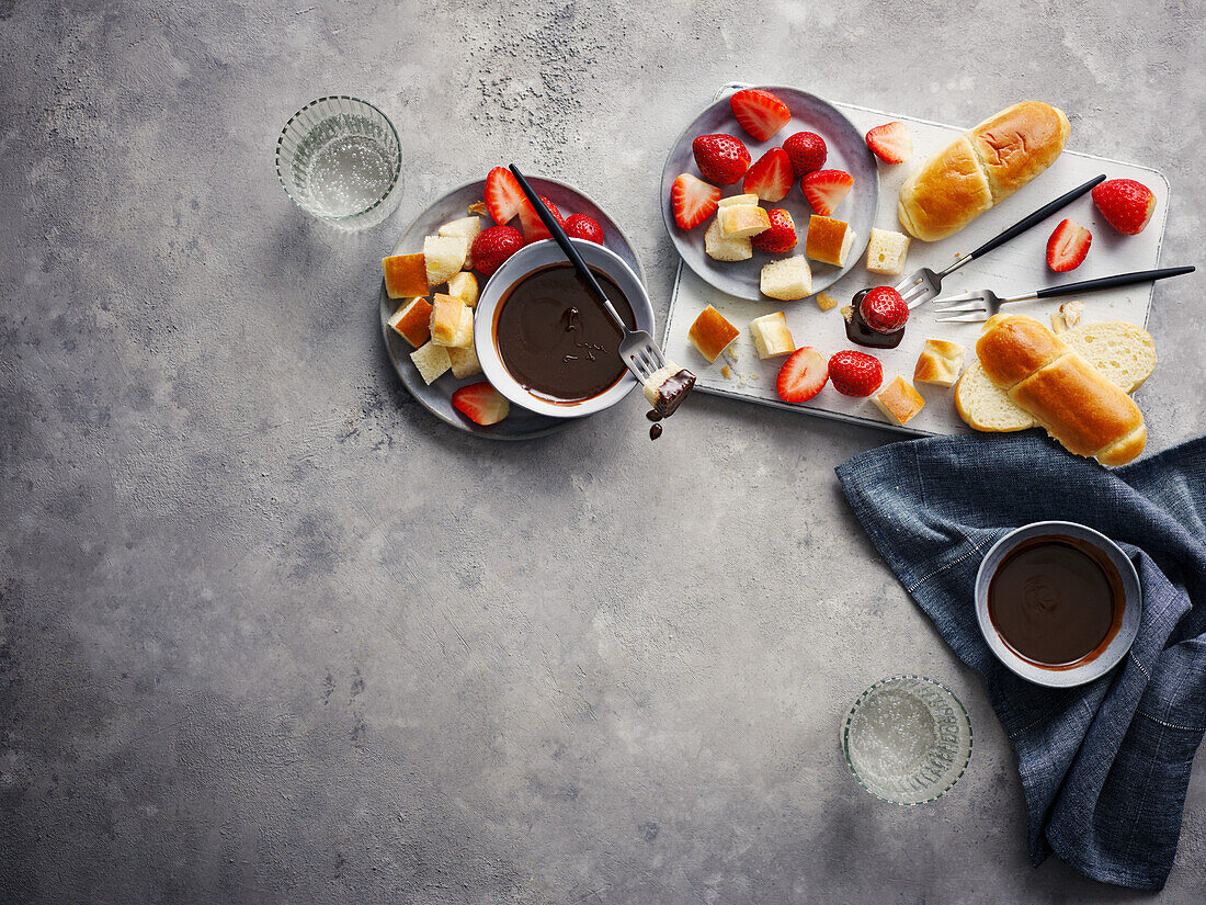 Chocolate hazelnut nougat dip with strawberries and rolls