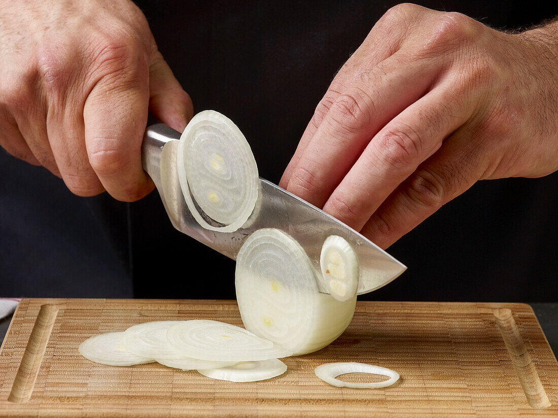 Weiße Zwiebel in Scheiben schneiden (Nahaufnahme)