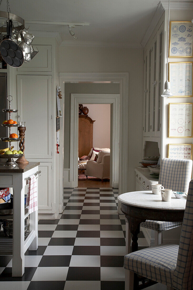 Cups on kitchen table with matching chairs in kitchen corridor