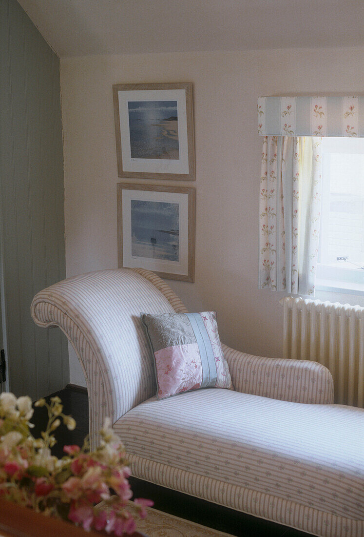 Chaise longue with cushion by a window in a country style room