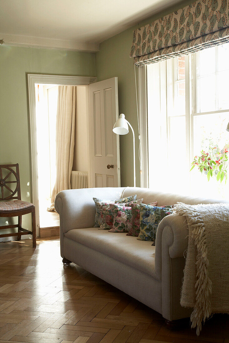 Cream sofa with blanket at sunlit window in Rye, Sussex