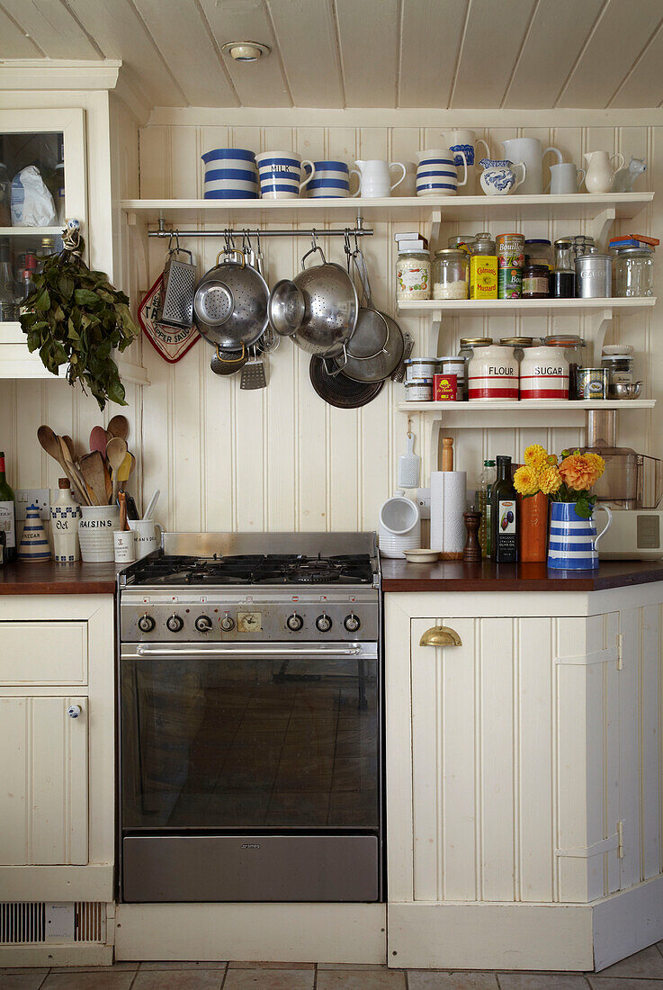 Vertäfelte Küchenschränke mit Ofen und offenen Regalen