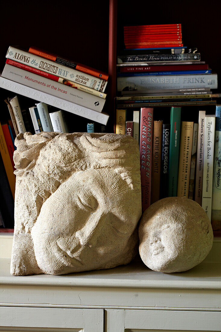 Zwei Statuen vor Bücherregal in einem Haus in Brighton, UK