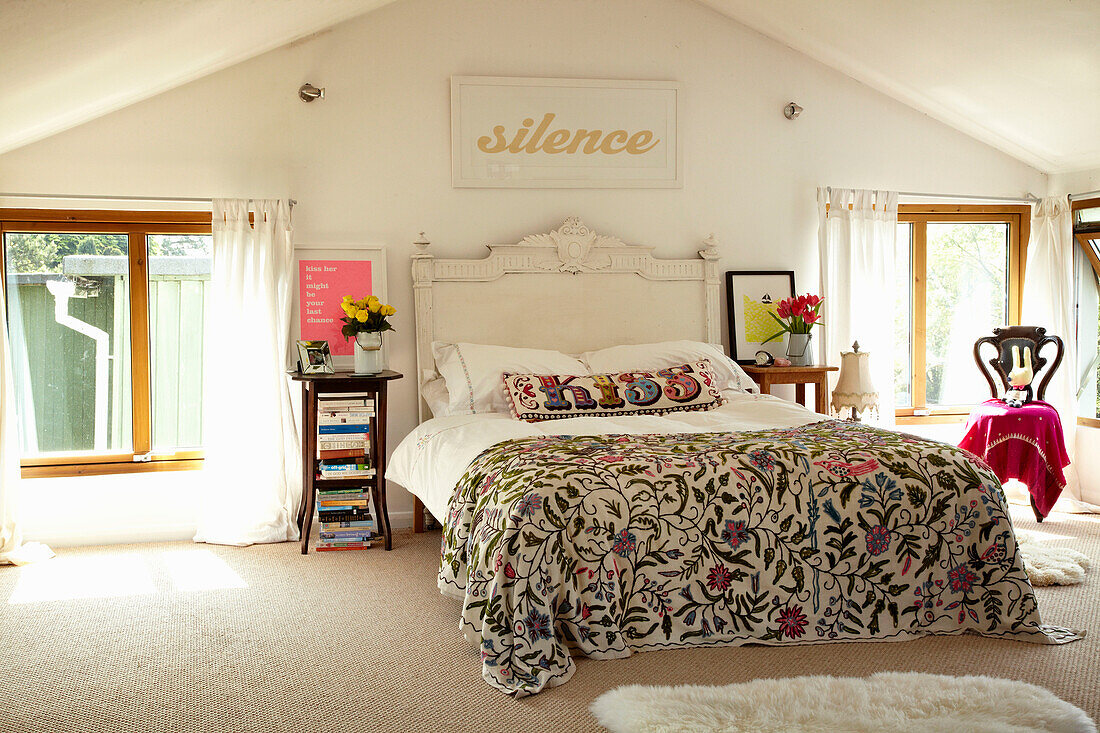 Embroidered bed cover on double bed in houseboat in Richmond upon Thames, England, UK