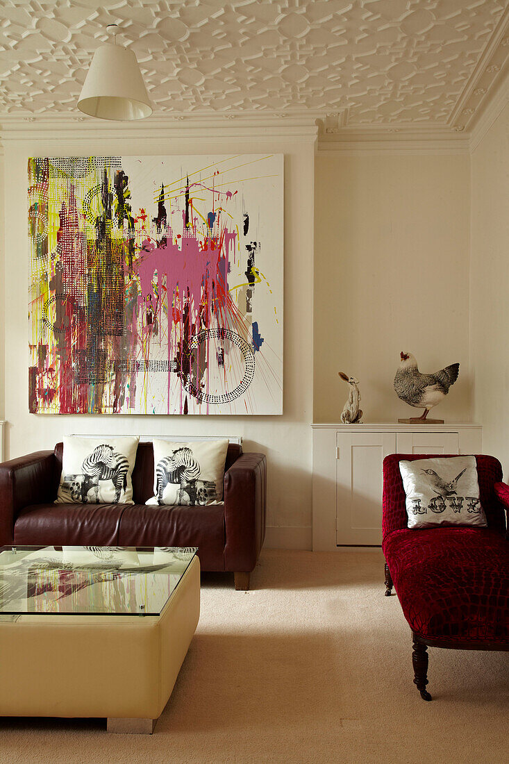 Sofas, abstraktes Gemälde und Stuckdecke in einem Stadthaus in Brighton, Sussex, England, UK