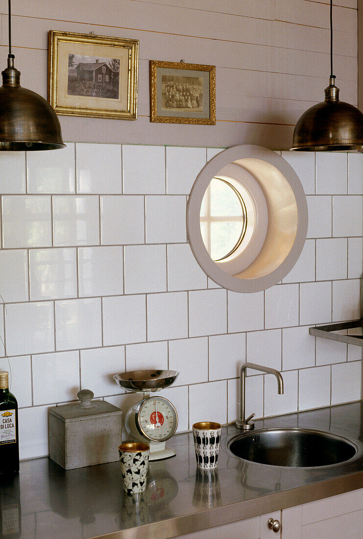 Kitchen with white tiles and a sink built into a stainless steel work top