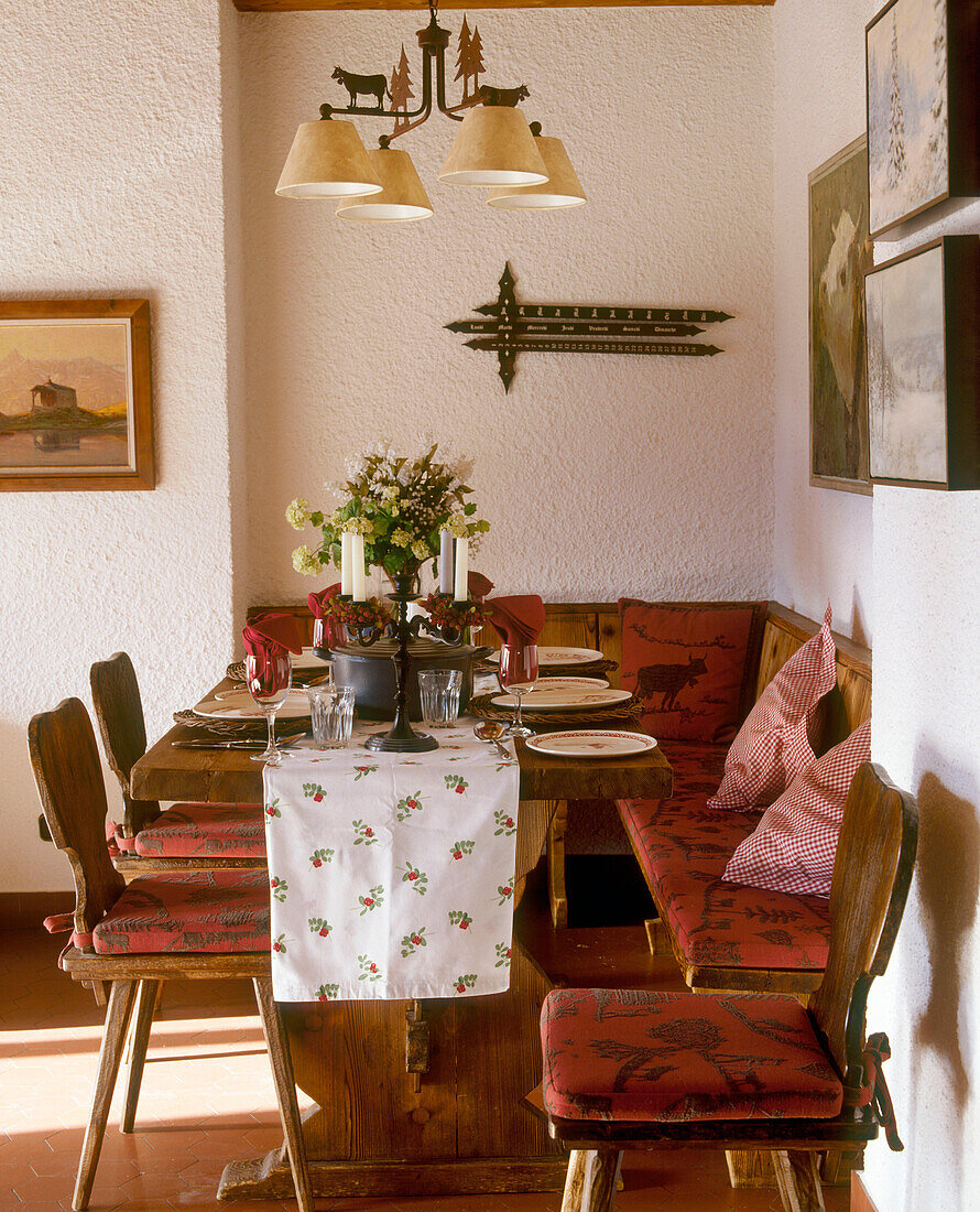 Ein Esszimmer im Landhausstil mit Holztisch, Stühlen und Kronleuchter