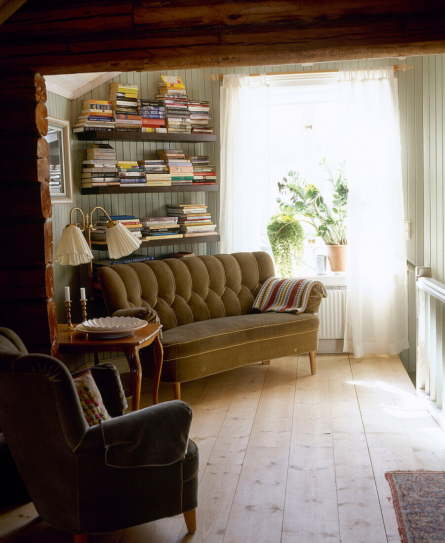 Upholstered sofa below shelving next to window