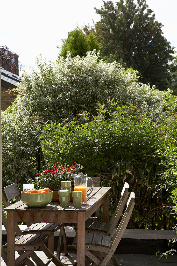 Holztisch und Stühle auf einer Dachterrasse