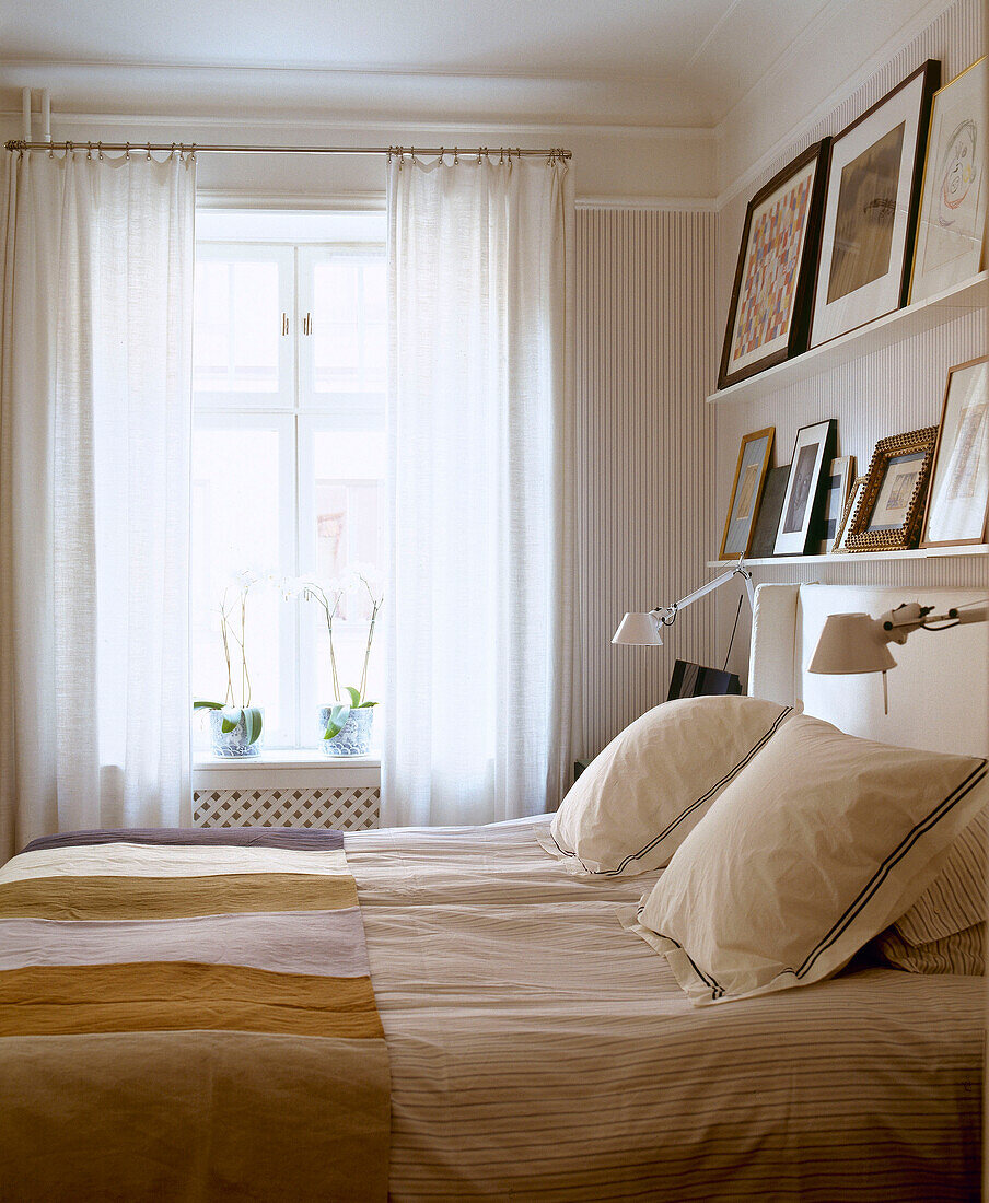 Shelving with pictures above double bed