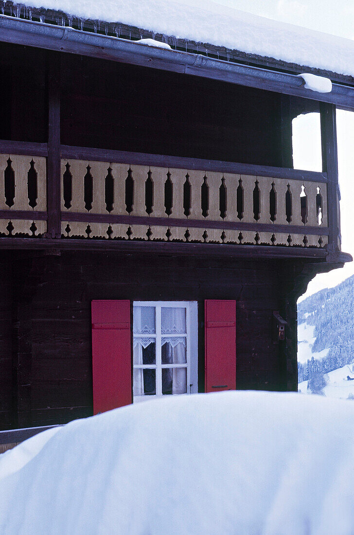 Außenansicht eines schneebedeckten schweizer Chalets in den Bergen