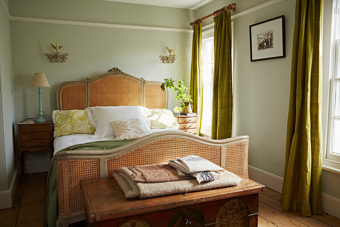 Wicker bed in light green Port Issac beach house bedroom Cornwall