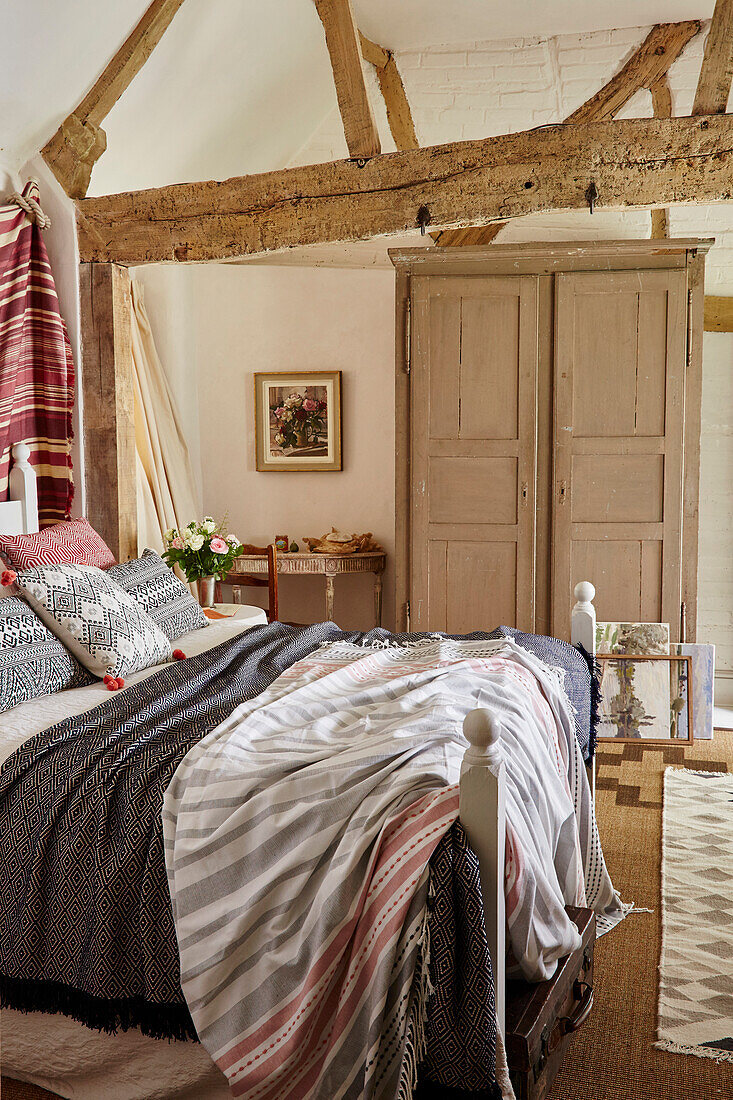 Bedroom in thatched 17th century cottage with painted wardrobe Hampshire, UK