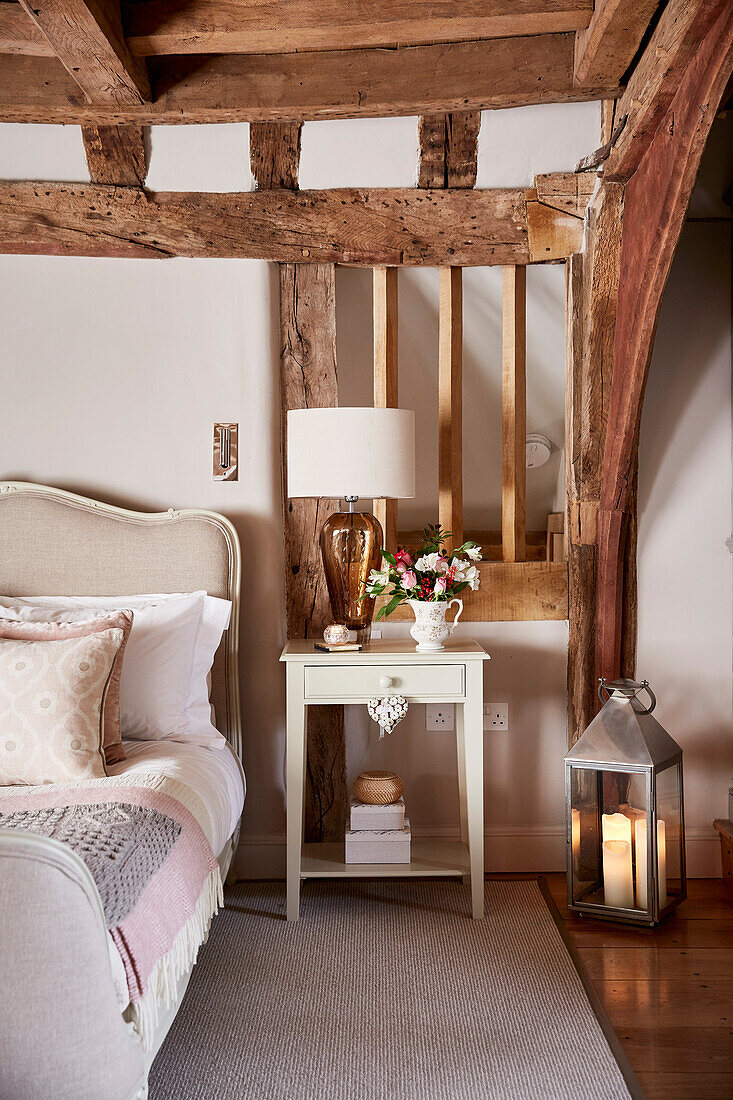 Lantern and table with French antique bed in beamed Grade II listed farmhouse Kent, UK