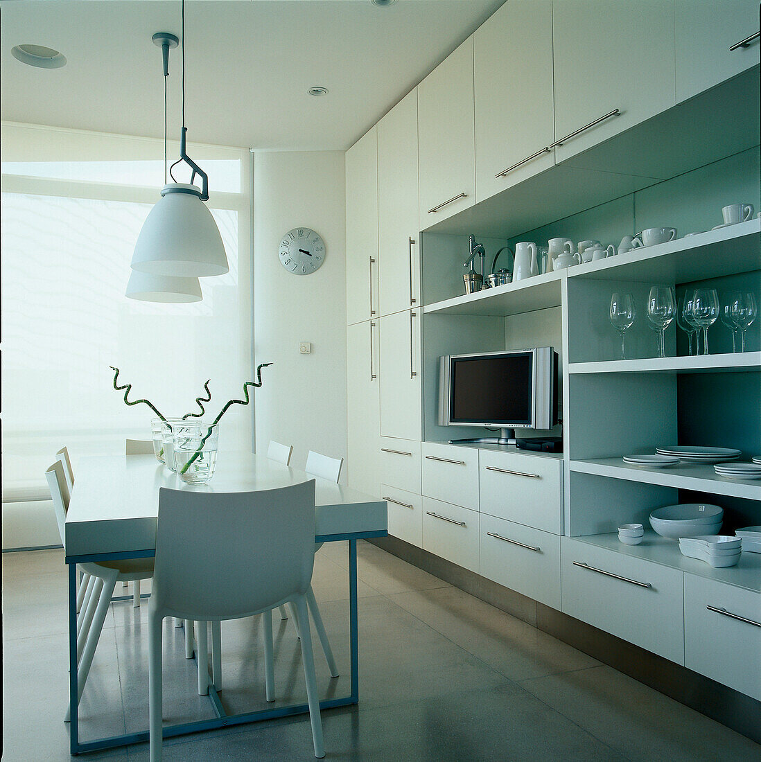 Moderne weiße Wohnküche mit großem Wandregal für Geschirr und Haushaltswaren