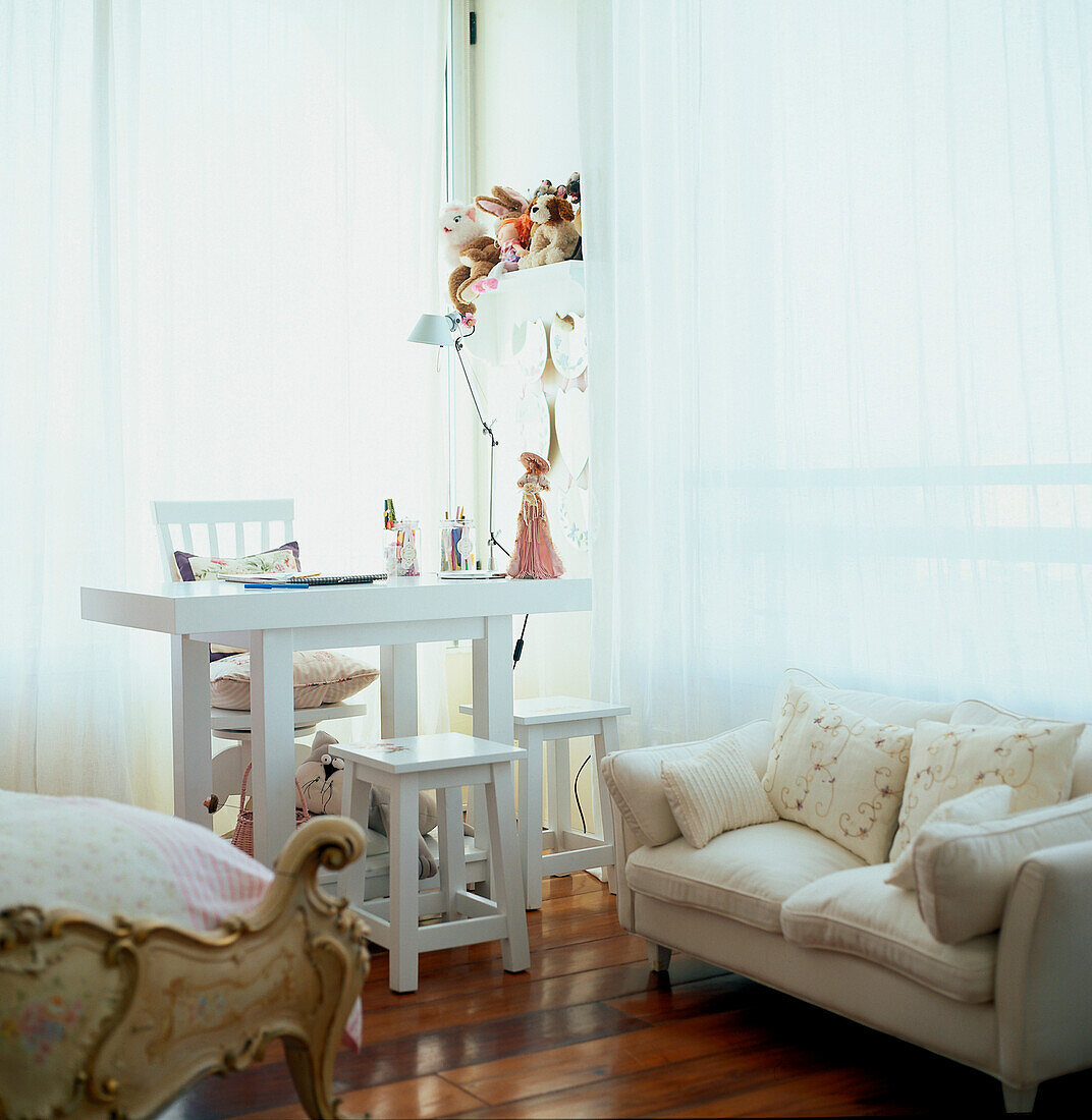 Contemporary child's bedroom with white desk chairs and stools and a small sofa