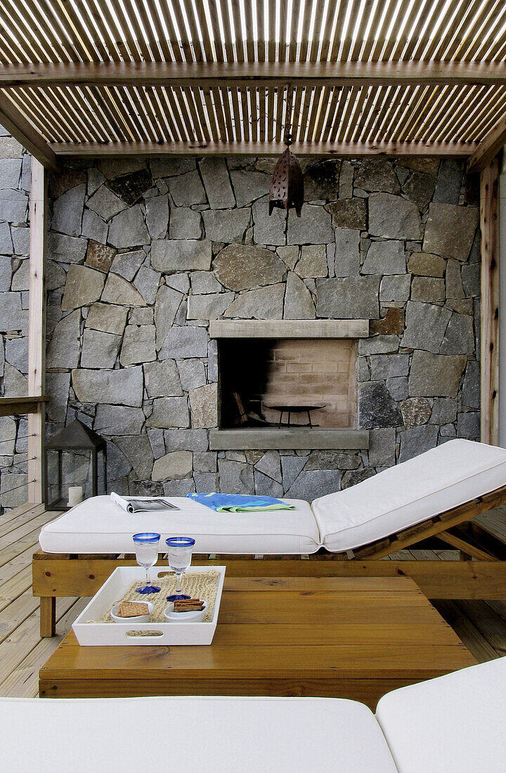 Grill set in exposed stone wall with sun lounger on shaded terrace