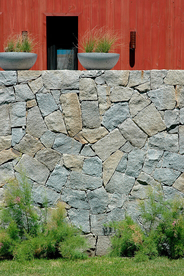 Beach house exterior with plant holders on stone wall
