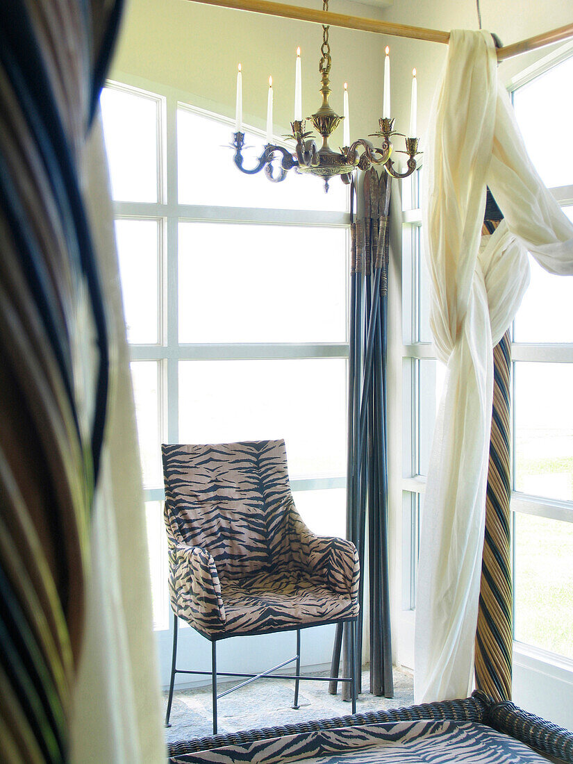 Animal print upholstered chair in bedroom with candelabra